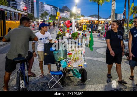 Un uomo vende bevande alcoliche da Un tram/carrello a Copacabana Beach, Rio de Janeiro, Brasile. Foto Stock