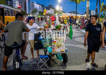 Un uomo vende bevande alcoliche da Un tram/carrello a Copacabana Beach, Rio de Janeiro, Brasile. Foto Stock