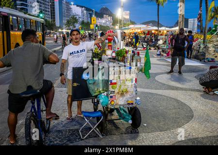 Un uomo vende bevande alcoliche da Un tram/carrello a Copacabana Beach, Rio de Janeiro, Brasile. Foto Stock