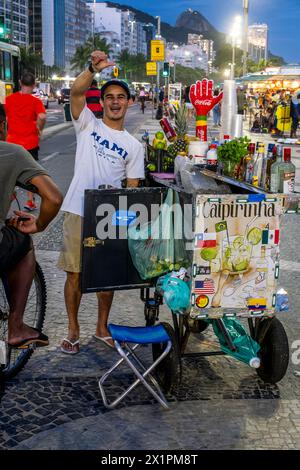 Un uomo vende bevande alcoliche da Un tram/carrello a Copacabana Beach, Rio de Janeiro, Brasile. Foto Stock