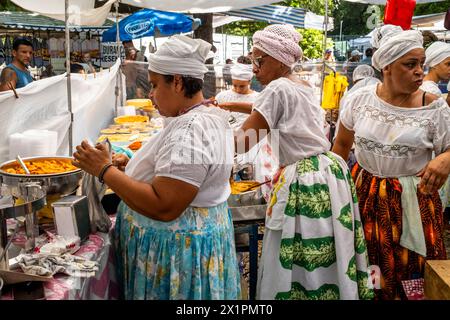 Donne brasiliane in costume tradizionale cucinare e preparare cibo in Un caffè presso il mercato domenicale di Ipanema (Fiera Hippie), Rio de Janeiro, Brasile Foto Stock