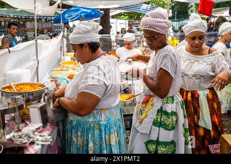 Donne brasiliane in costume tradizionale cucinare e preparare cibo in Un caffè presso il mercato domenicale di Ipanema (Fiera Hippie), Rio de Janeiro, Brasile Foto Stock