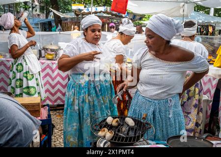 Donne brasiliane in costume tradizionale cucinare e preparare cibo in Un caffè presso il mercato domenicale di Ipanema (Fiera Hippie), Rio de Janeiro, Brasile Foto Stock