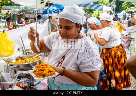 Brasilian Women in Traditional Costume serve cibo in Un Cafe presso il mercato domenicale di Ipanema (Fiera Hippie), Rio de Janeiro, Stato di Rio de Janeiro, Brasile. Foto Stock