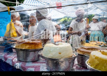 Donne brasiliane in costume tradizionale cucinare e preparare cibo in Un caffè presso il mercato domenicale di Ipanema (Fiera Hippie), Rio de Janeiro, Brasile. Foto Stock