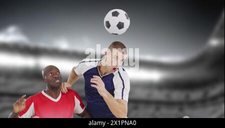 Due giocatori di calcio che competono per il pallone a mezz'aria sul campo Foto Stock