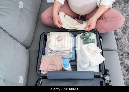 Vista dall'alto di una donna incinta che confeziona una serie di cose necessarie nell'ospedale di maternità Foto Stock