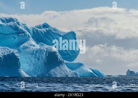 Un tranquillo paesaggio antartico, vicino al passaggio Graham lungo Charlotte Bay, che mette in evidenza forti riflessi, aspre montagne e suggestivi iceberg. Foto Stock
