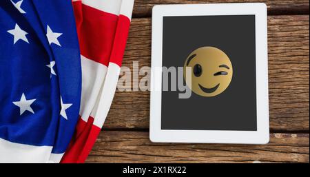 Accanto alla bandiera americana è presente una tavoletta che mostra emoji Foto Stock