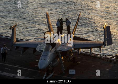 240415-N-PG226-1581 OCEANO ATLANTICO (15 aprile 2024) i marinai, assegnati ai “Knighthawks” dello Strike Fighter Squadron (VFA) 136, preparano un F/A-18E S. Foto Stock