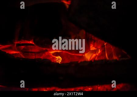 Cattura l'essenza dell'inferno con un primo piano di fuoco a legna ardente, con fiamme ardenti e calore ardente. Foto Stock