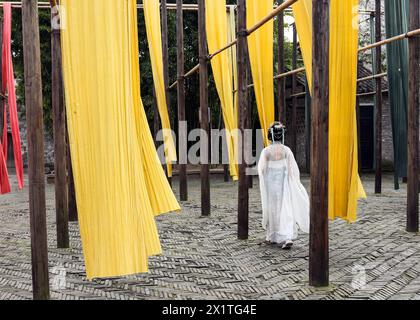 (240418) -- JIAXING (ZHEJIANG), 18 aprile 2024 (Xinhua) -- Un turista che indossa abiti tradizionali di Hanfu visita una casa di tintura nella città sull'acqua di Wuzhen nella città di Jiaxing, nella provincia di Zhejiang della Cina orientale, 11 aprile 2024. Situata nella provincia di Zhejiang della Cina orientale, la città sul mare di Jiaxing è rinomata per le destinazioni turistiche del lago Nanhu e Wuzhen. Nel mese di aprile, i due luoghi turistici si animano con il delicato tocco di primavera. Il lago Nanhu, con le sue acque scintillanti e gli alberi di salice che ondeggiano lungo il lago, è uno spettacolo da vedere. Anche la storica città sull'acqua di Wuzhen incanta l'ingegno Foto Stock