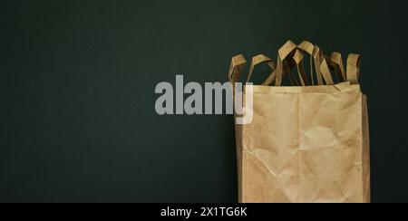 Sacchetti di carta, cartone. Stoccaggio e uso dei sacchetti. Imballaggio della spesa. Sfondo scuro. Copia spazio. Minimalismo Foto Stock