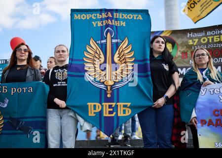 Le donne ucraine detengono uno stemma di un marines ucraino in una manifestazione pubblica. Kiev - 13 aprile 2024 Foto Stock