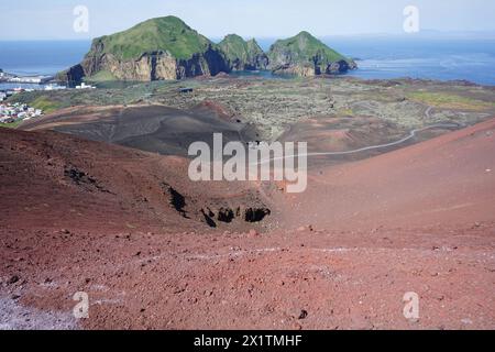 Vista di Heimaey, del monte Heimaklettur e del vasto campo lavico dalla cima del cono vulcanico Eldfell, delle isole Westman, Islanda Foto Stock