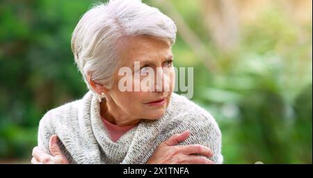 Depressione, triste e donna anziana in parco all'aperto per lutto, ansia o salute mentale in casa di riposo. Pianto, memoria e persona anziana con Foto Stock