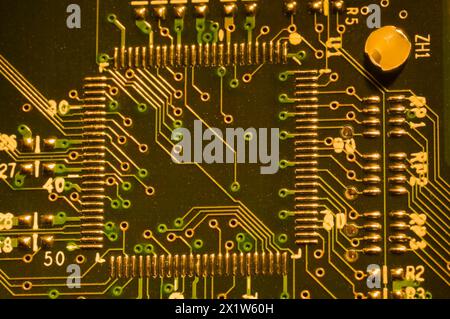 Primo piano di microchip, punti di saldatura in argento e linee su circuiti stampati elettronici illuminati dorati, Studio Composition, Quebec, Canada Foto Stock