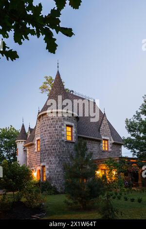 2006 riproduzione di una facciata residenziale in pietra grigia e mortaio del XVI secolo in stile castello rinascimentale al crepuscolo in estate, Quebec, Canada Foto Stock