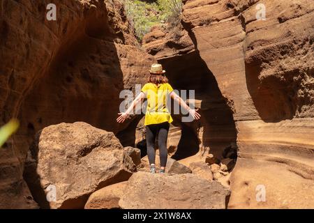 Una donna con un cappello nel canyon calcareo Barranco de las Vacas a Gran Canaria, Isole Canarie Foto Stock