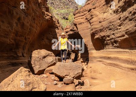 Una donna turistica con cappello nel canyon calcareo Barranco de las Vacas a Gran Canaria, Isole Canarie Foto Stock