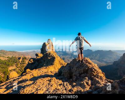 Un turista a braccia aperte sulla cima di Pico de las Nieves a Gran Canaria, Isole Canarie Foto Stock