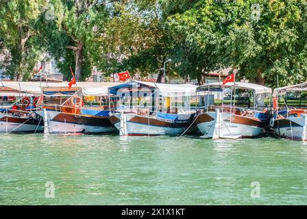 Dalyan, Turchia - 13 settembre 2015: Imbarcazioni turistiche attraccate pacificamente sul bordo dei fiumi, abbracciate da una vegetazione lussureggiante Foto Stock