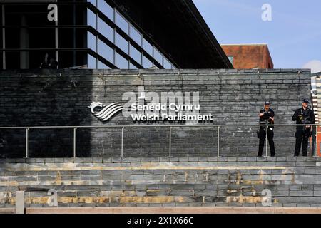 Edificio del Parlamento gallese con due poliziotti armati a guardia dell'ingresso. Preso nell'aprile 2024 Foto Stock