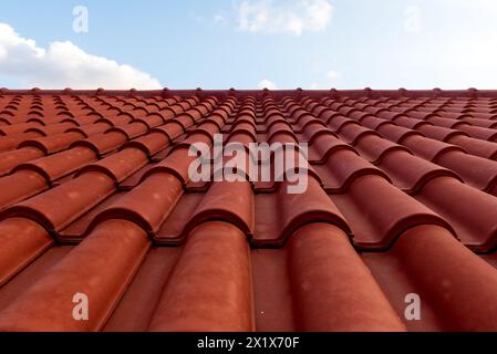 Tetto in piastrelle rosse sotto il cielo blu. Una parte è un tetto e l'altra è un cielo blu puro. Foto Stock