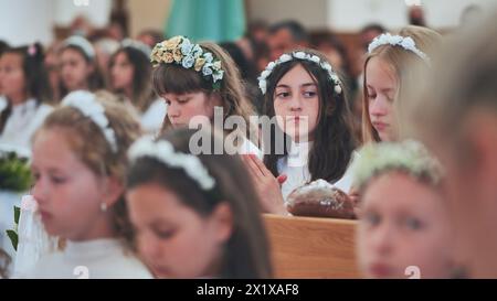 Lida, Bielorussia - 31 maggio 2022: Bambini in una chiesa cattolica durante la loro prima comunione. Foto Stock