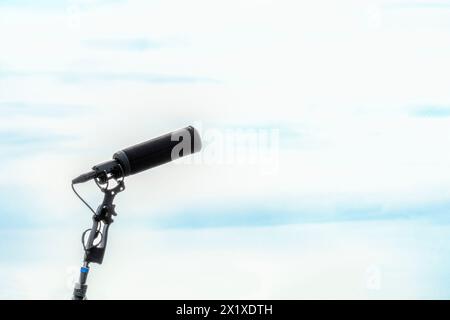 Microfono a pistola senza protezione isolato sullo sfondo del cielo. microfono sulla chiavetta per un audio professionale nitido Foto Stock