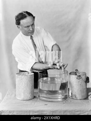 Harry Houdini realizza mani spirituali - 1923 - in questa sequenza di fotografie Houdini ha dimostrato come le mani spiritose apparse alle sedute fossero fatte da esseri meno eterei. In "Un mago tra gli spiriti" Houdini descrisse la frode mediumistica nota come "impronte digitali di uno spirito". Una sagoma della mano di un morto sarebbe stata accuratamente preparata e, durante una seduta con i parenti creduti, le impronte digitali del defunto apparivano su una tromba nera di lampione. Nel suo libro Houdini ha dichiarato quanto segue: "Ci sono due casi registrati in cui le fortune erano in gioco a causa di questo tipo di frode. In uno Foto Stock
