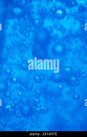 Le bolle nella macro acqua blu chiudono lo sfondo astratto Foto Stock