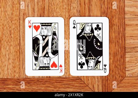 Carta King of Hearts e Queen of Clubs affiancati, uno di fronte all'altro, opposizione e differenze tra uomo e donna socialmente culturali Foto Stock