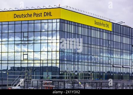 Aeroporto internazionale di Francoforte, Germania - 19 febbraio 2024: Il marchio "Deutsche Post DHL" si trova su un edificio con una facciata riflettente al Frankfurt in Foto Stock