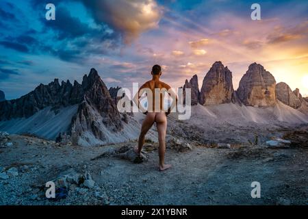 Descrizione: L'uomo sportivo gode di una vista epica da Sextner Stein sul Monte Paterno e sulle tre Cime la sera. Tre Cime, Dolomiti, Sud Foto Stock