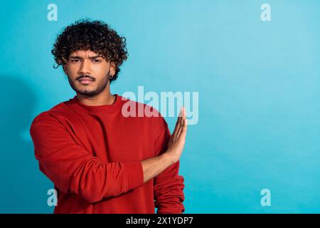 Foto del palmo della mano di un ragazzo focalizzato che mostra il simbolo di stop-rigetto, lo spazio vuoto isolato su sfondo blu Foto Stock