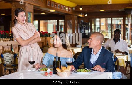 Triangolo d'amore - moglie ha preso marito con la padrona nel ristorante Foto Stock