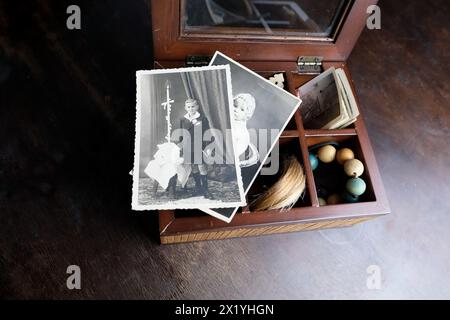 primo piano di una vecchia scatola di legno, una pila di foto retrò, una ciocca di capelli, fotografie d'epoca del 1960, concetto di albero genealogico, genealogia, ricordi d'infanzia Foto Stock