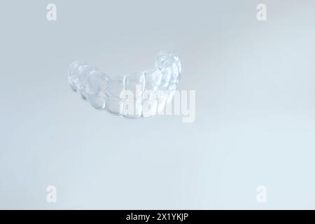 Primo piano di protezione della bocca notturna in silicone trasparente per il fissaggio dei denti smerigliatura dentaria supporto per il sonno, servizi odontoiatrici concettuali, rimedio per la smerigliatura Foto Stock