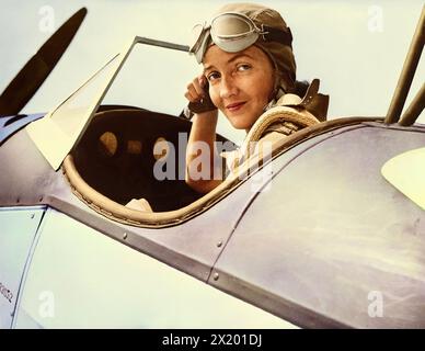 Nancy Harkness Love, 28 anni, direttrice dello U.S. Women's Auxiliary Ferry Squadron, regola il suo casco nella cabina di pilotaggio di un Fairchild PT-19, un aereo dell'esercito, prima di decollare da una base orientale degli Stati Uniti. Le donne sotto il suo comando trasporteranno aerei dalle fabbriche agli aeroporti costieri, da cui saranno trasportati ai fronti di battaglia oltremare. Tra il 1942 e il 1945. Foto Stock