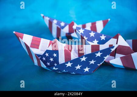 Barca di carta con bandiera americana su sfondo blu. Columbus Day Concept. Foto Stock