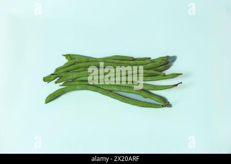 Un mucchio di fagiolini freschi sparsi su uno sfondo bianco isolato e pulito. Foto Stock
