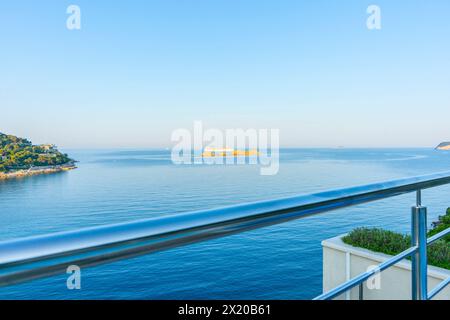 Vista dalla ringhiera del balcone sul Mar Mediterraneo mentre la nave da crociera passa per piccole isole al largo della costa croata di Dubrovnik, Croazia Foto Stock