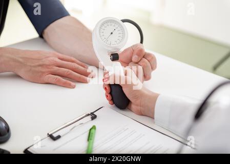 Un esperto medico si concentra sulla scrittura delle informazioni vitali in un ambiente clinico. Foto Stock