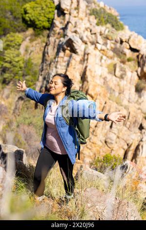 Escursionista birazziale, braccia allungate per divertirsi, avventura nella natura Foto Stock