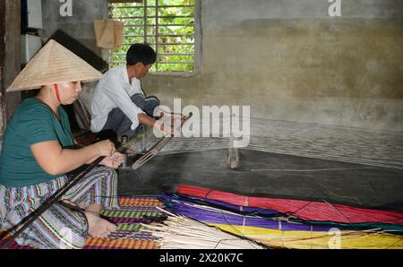 Un tessitore di tappeti che lavora nella sua casa in un piccolo villaggio a Cẩm Kim, Hội An, Vietnam. Foto Stock