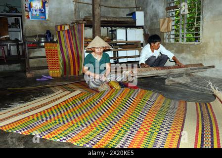 Un tessitore di tappeti che lavora nella sua casa in un piccolo villaggio a Cẩm Kim, Hội An, Vietnam. Foto Stock