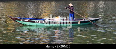 Una donna vietnamita che canta trasportando merci o persone attraverso il fiume Thu Bon a Hội An, Vietnam. Foto Stock