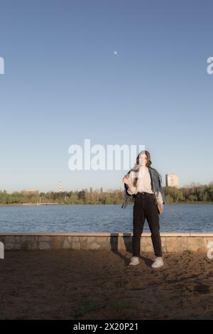 Ritratto di una bella ragazza con un libro. Sta succedendo da qualche parte nel parco. Primo piano. Foto Stock