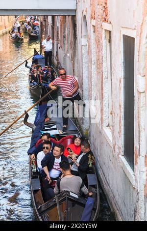 VENEZIA, ITALIA - 18 MAGGIO 2018: Gruppi non identificati di turisti fanno un giro di massa simultaneo verso una destinazione popolare lungo il canale Rio de Vin. Foto Stock